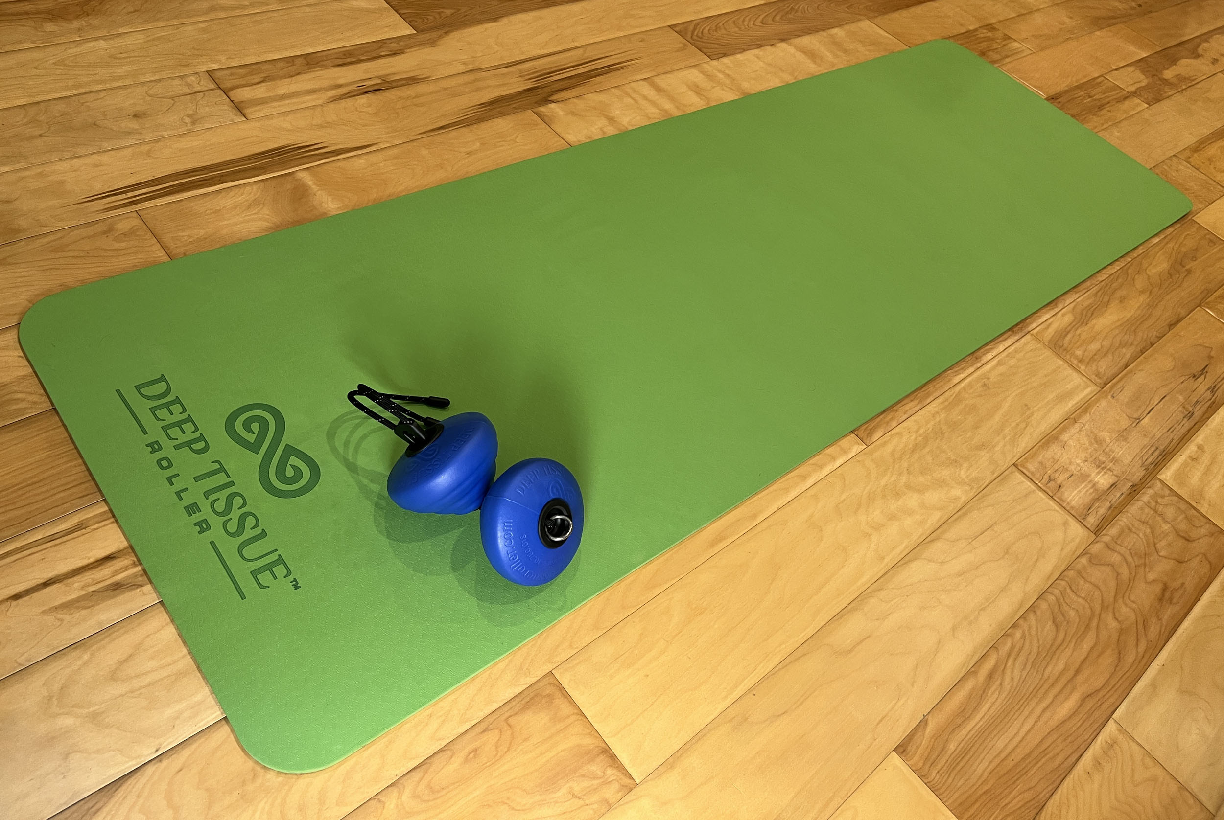 Deep Tissue Roller on a Green Yoga Mat